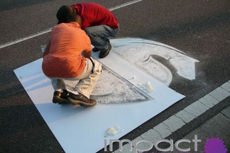 2 artists draw brand logo in street using chalk for marketing campaign