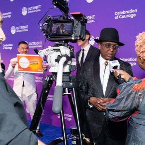 An international human rights activist giving a press interview on the blue carpet at the Celebration of Courage gala
