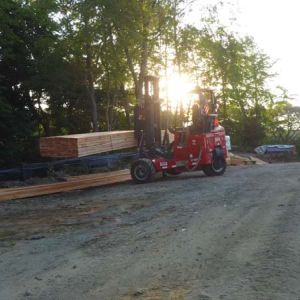 Cinematic sunrise production shot of a forklift moving lumber on the This Old House Cottage Community jobsite, captured by Impact Studios.