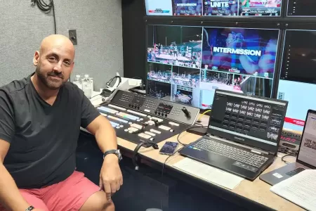 Director John Carboni operating video switcher in mobile multi-camera production truck