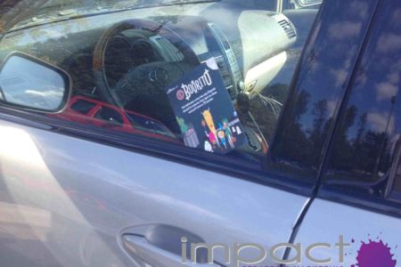 Placing coupons on cars at street festival. Guerilla marketing activation for restaurant client.